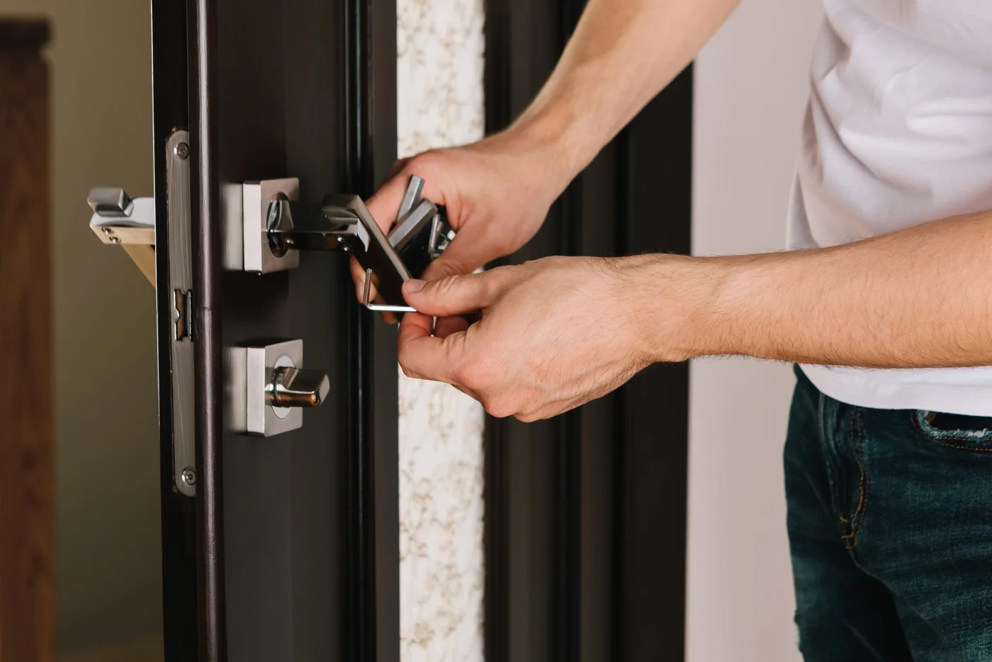 Serrurier de dépannage posant un verrou sur une porte d'entrée