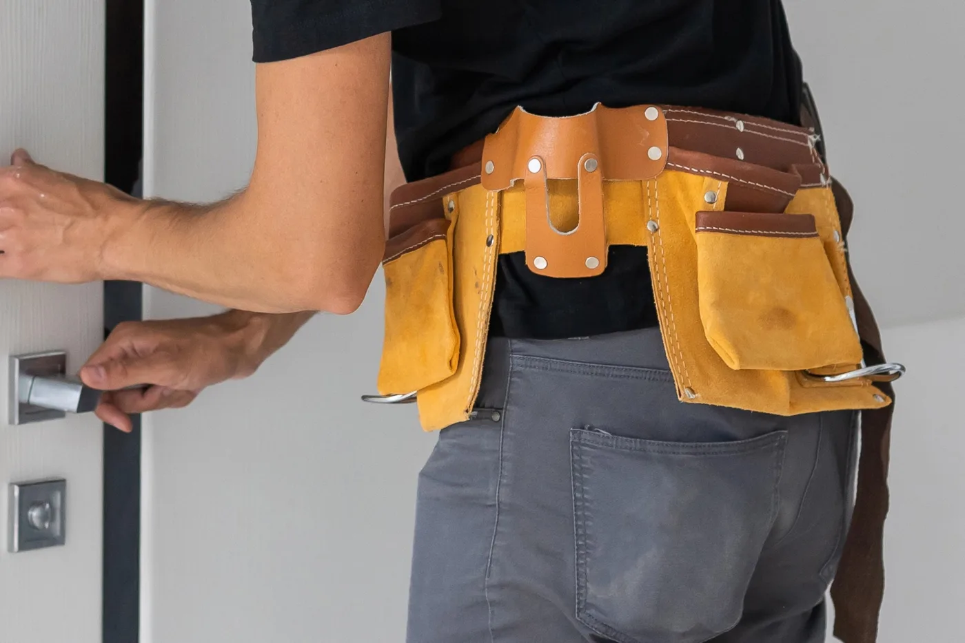Serrurier posant une serrure sur une porte lors d'un dépannage